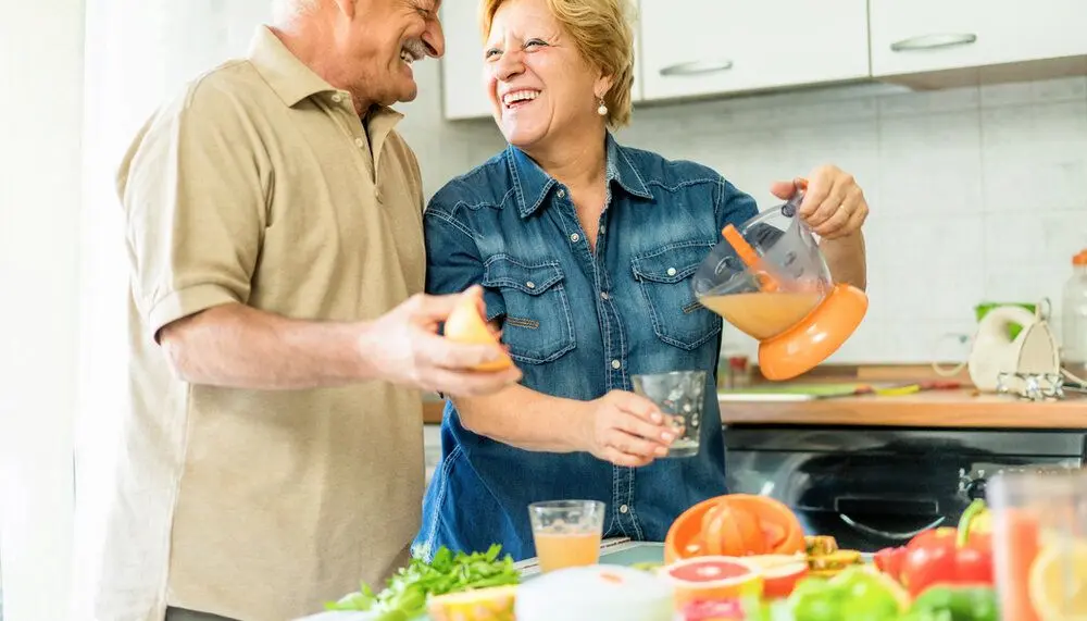 An elderly couple making breakfast