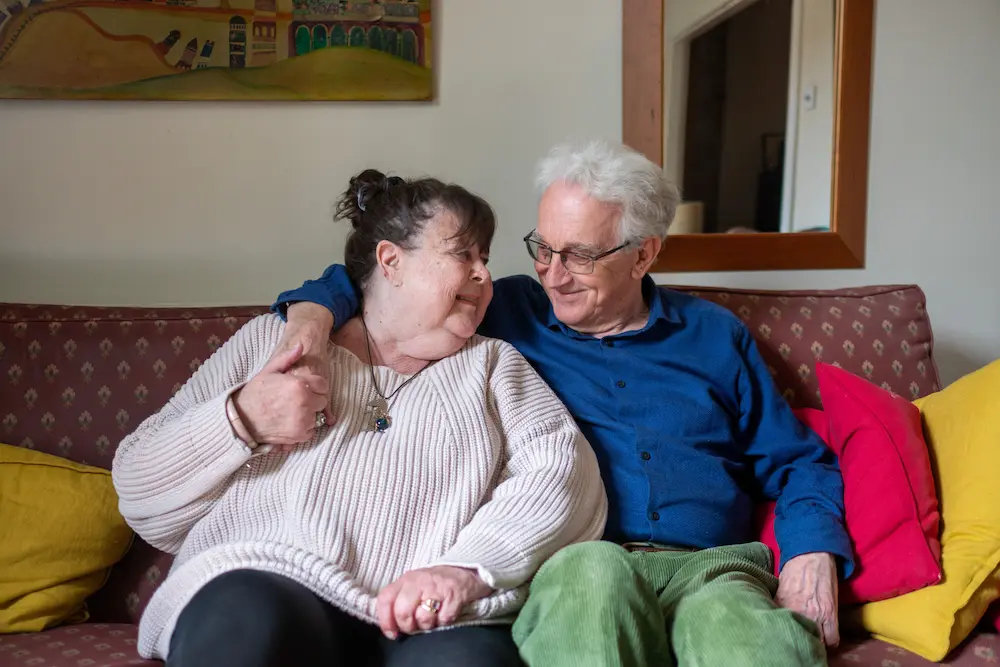 An older couple sitting on a sofa together