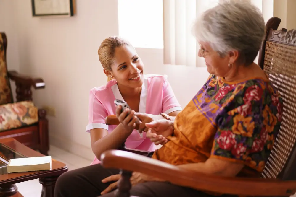 Carer holding an older woman's hand