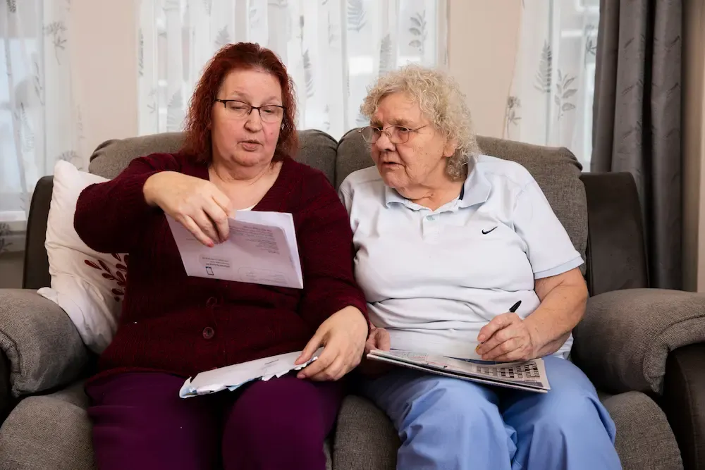 Female carer and older woman sat together