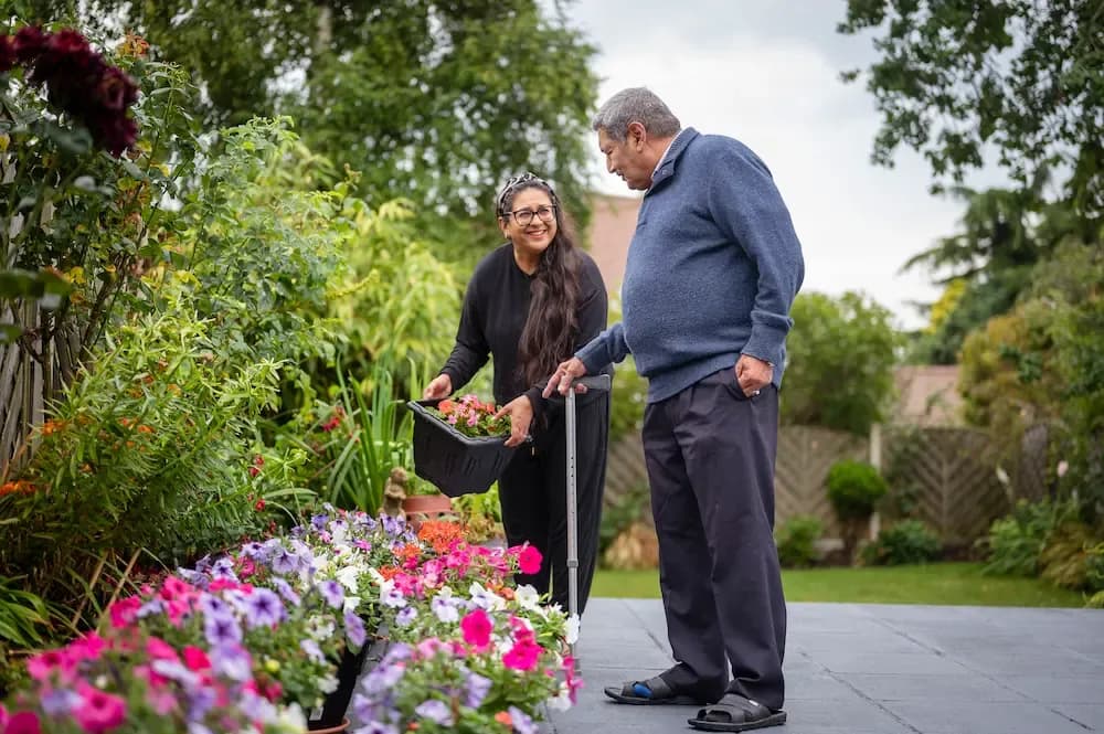 Female carer gardening with older man