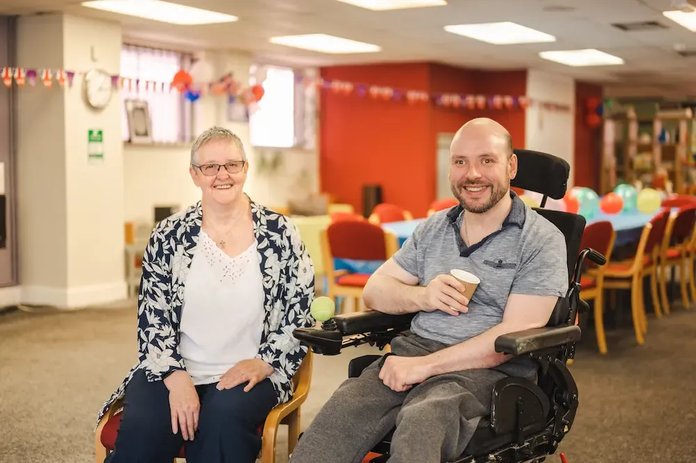 Female carer sitting with a man in a wheelchair