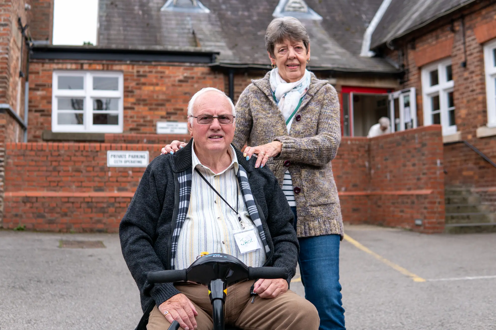 Man on a mobility scooter with his partner