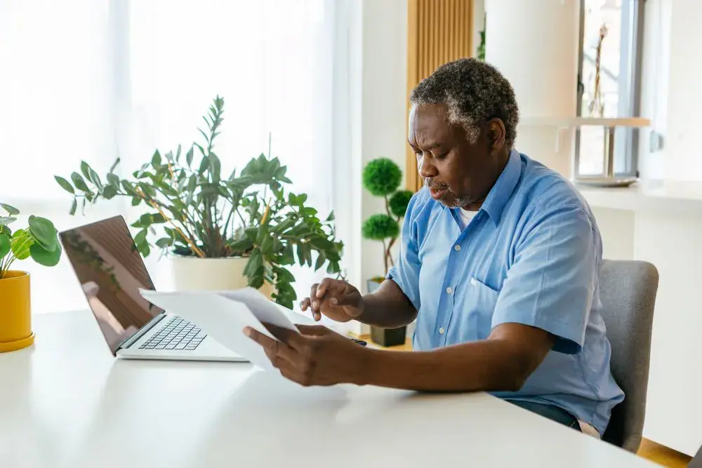 Middle-aged man reading document and typing