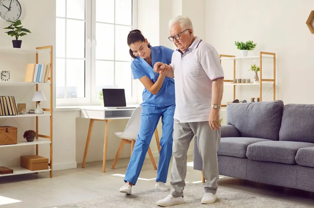 Older man and female nurse walking together