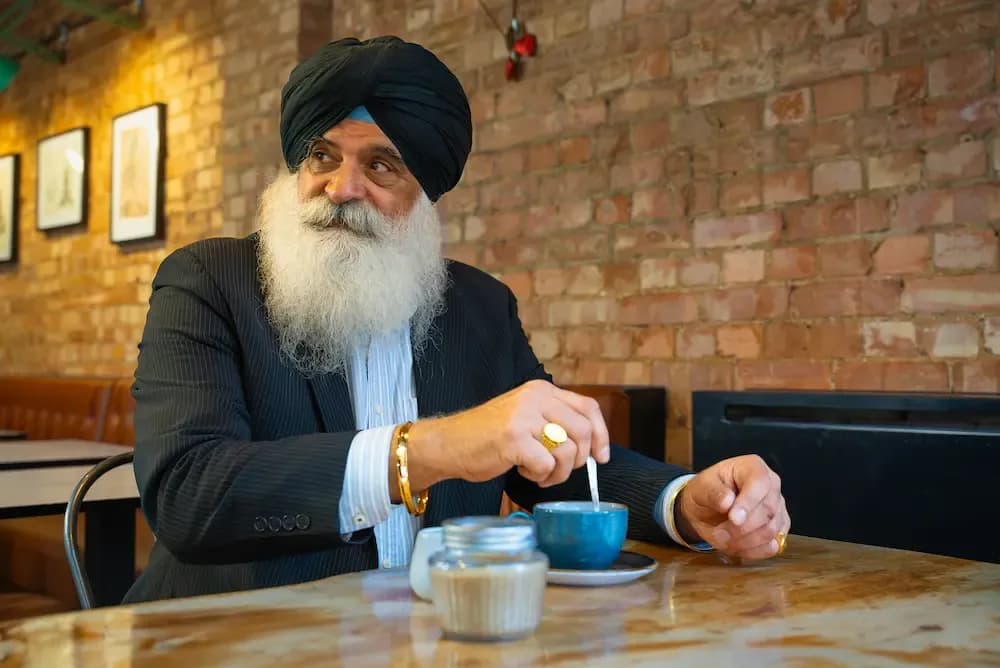 Older man drinking a hot drink in a café