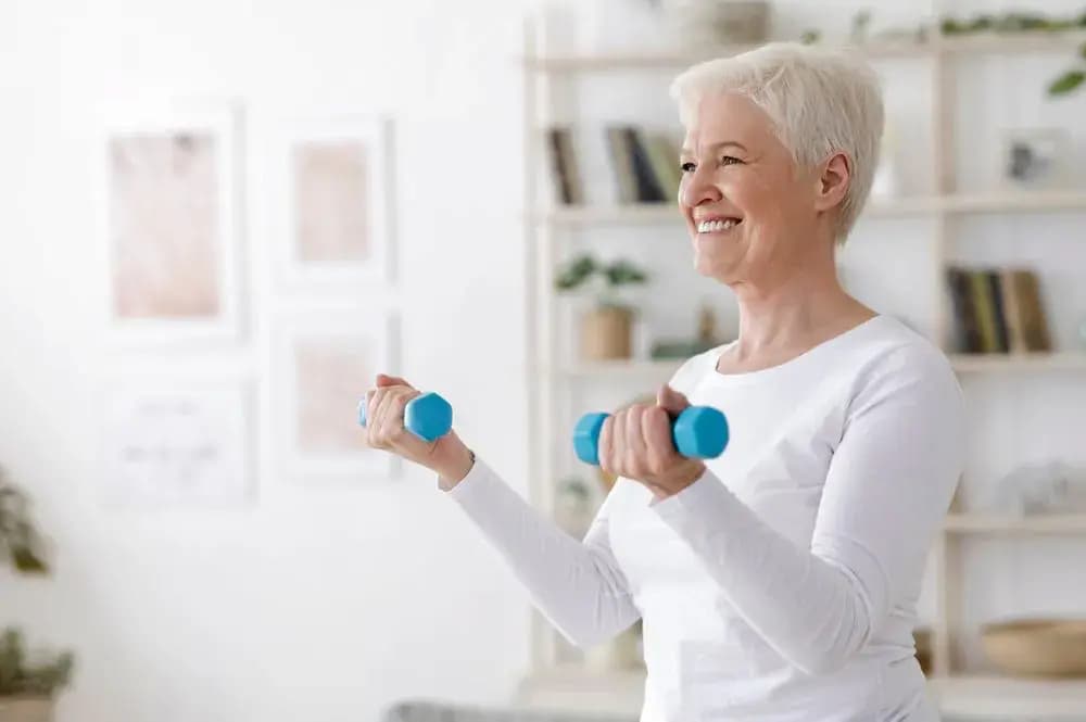 Older woman lifting light dumbbells