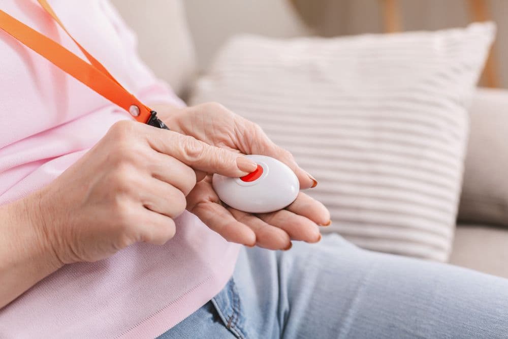 Older woman pressing an emergency personal alarm