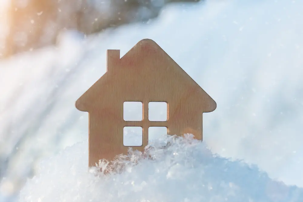 Small wooden house surrounded by snow