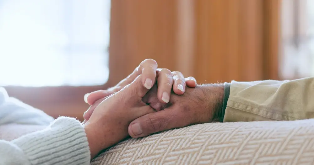 Two older adults holding hands