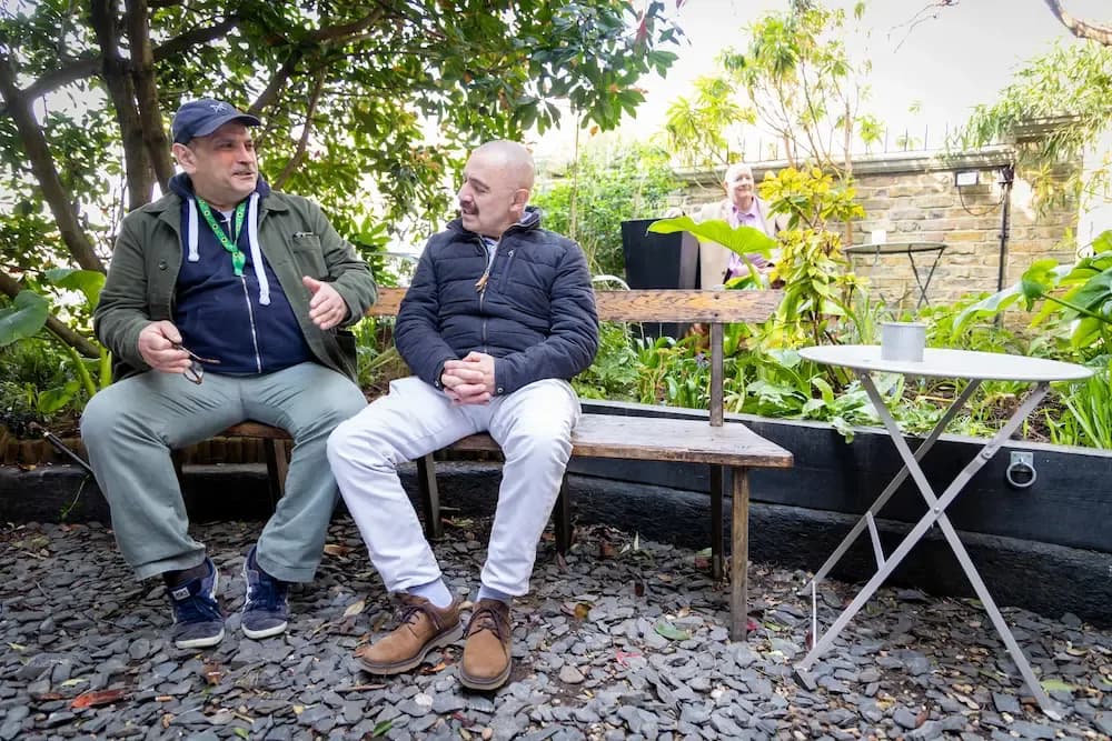 Two older men sitting in a garden