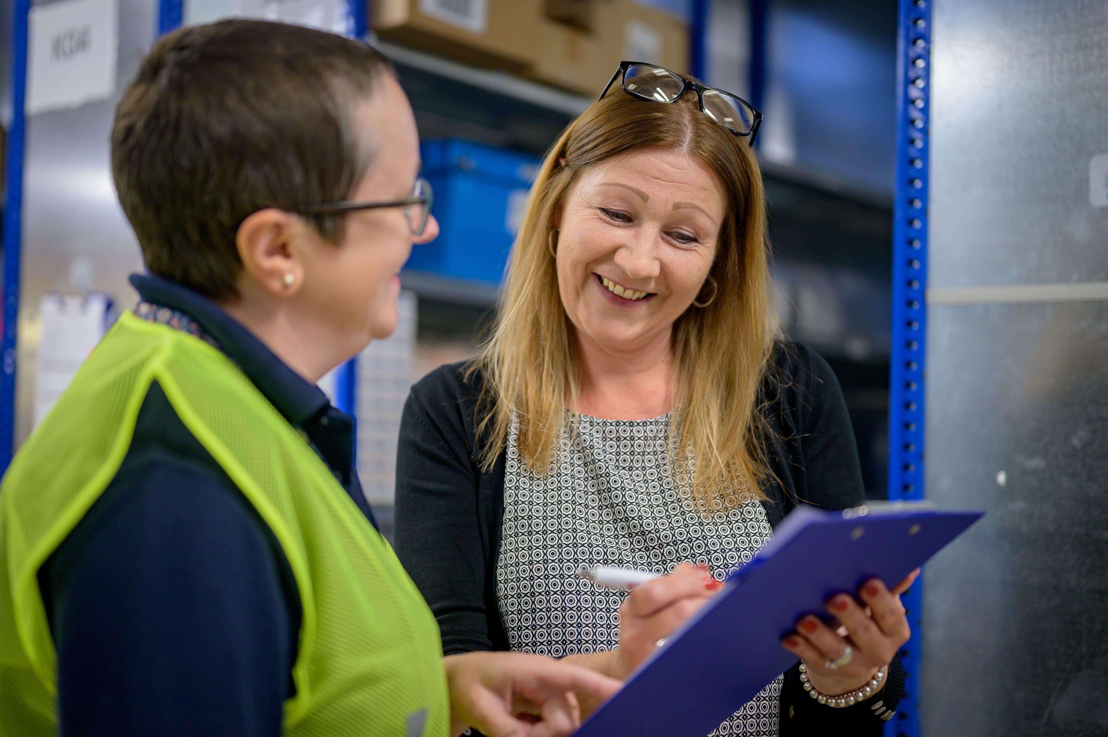 Two women chatting while looking at a clipboard