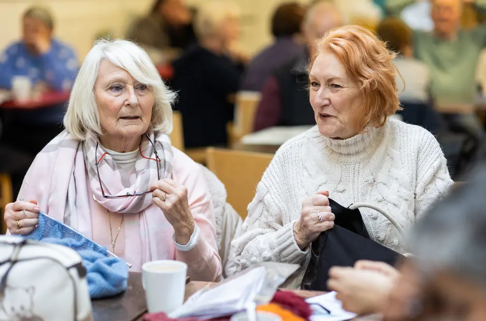 Two women knitting together