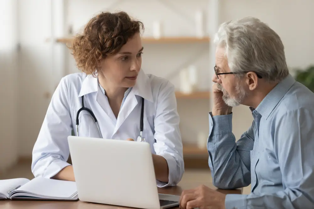 Younger female doctor and older male patient