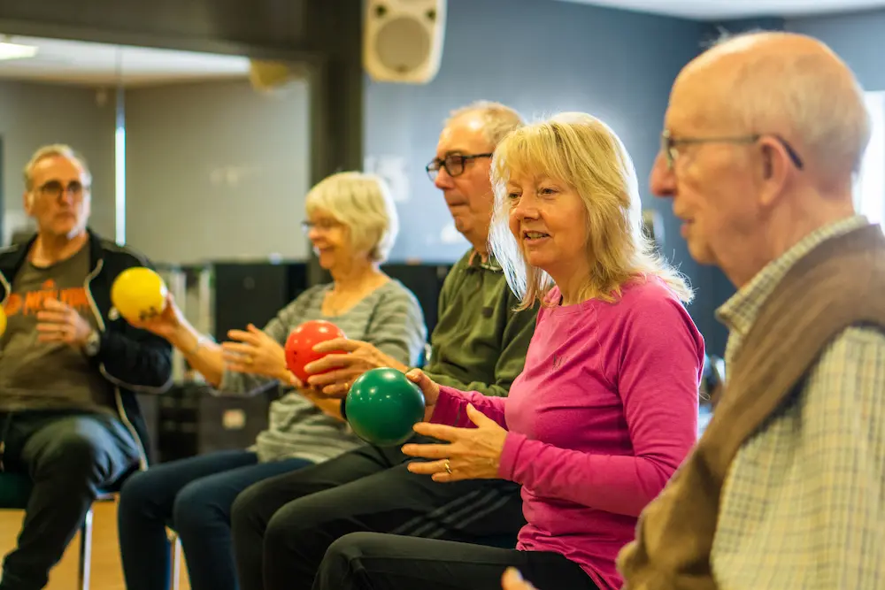 A group of older adults sat down and playing a game