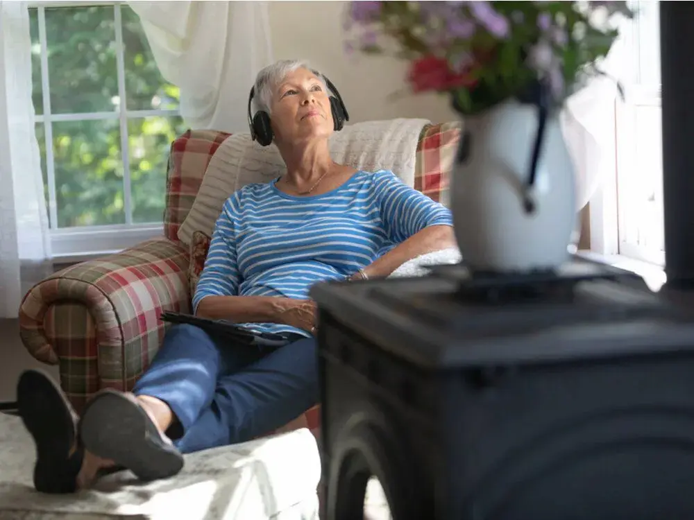 A woman listening to music in an elderly living facility