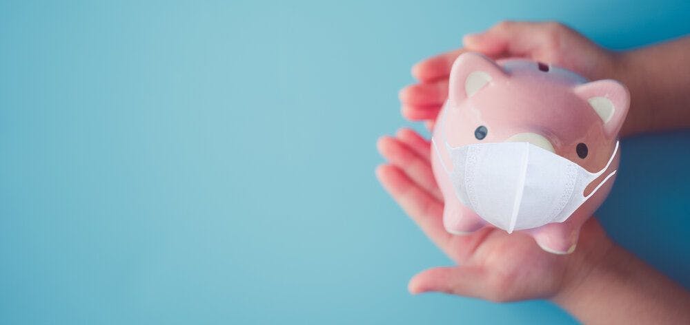 A piggy bank with a medical mask on