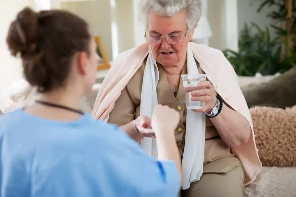 Nurse giving oral medication to a resident