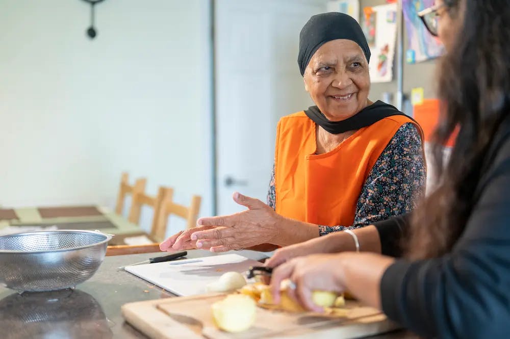 Older and younger woman preparing food together