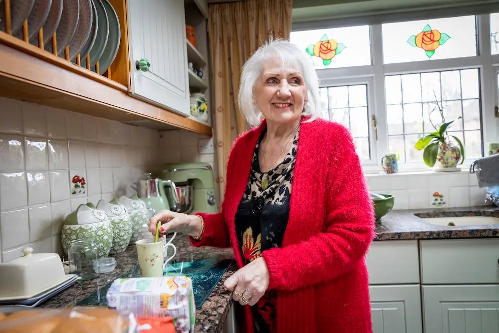 Older woman making a mug of tea