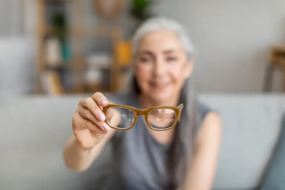 Woman holding a pair of glasses