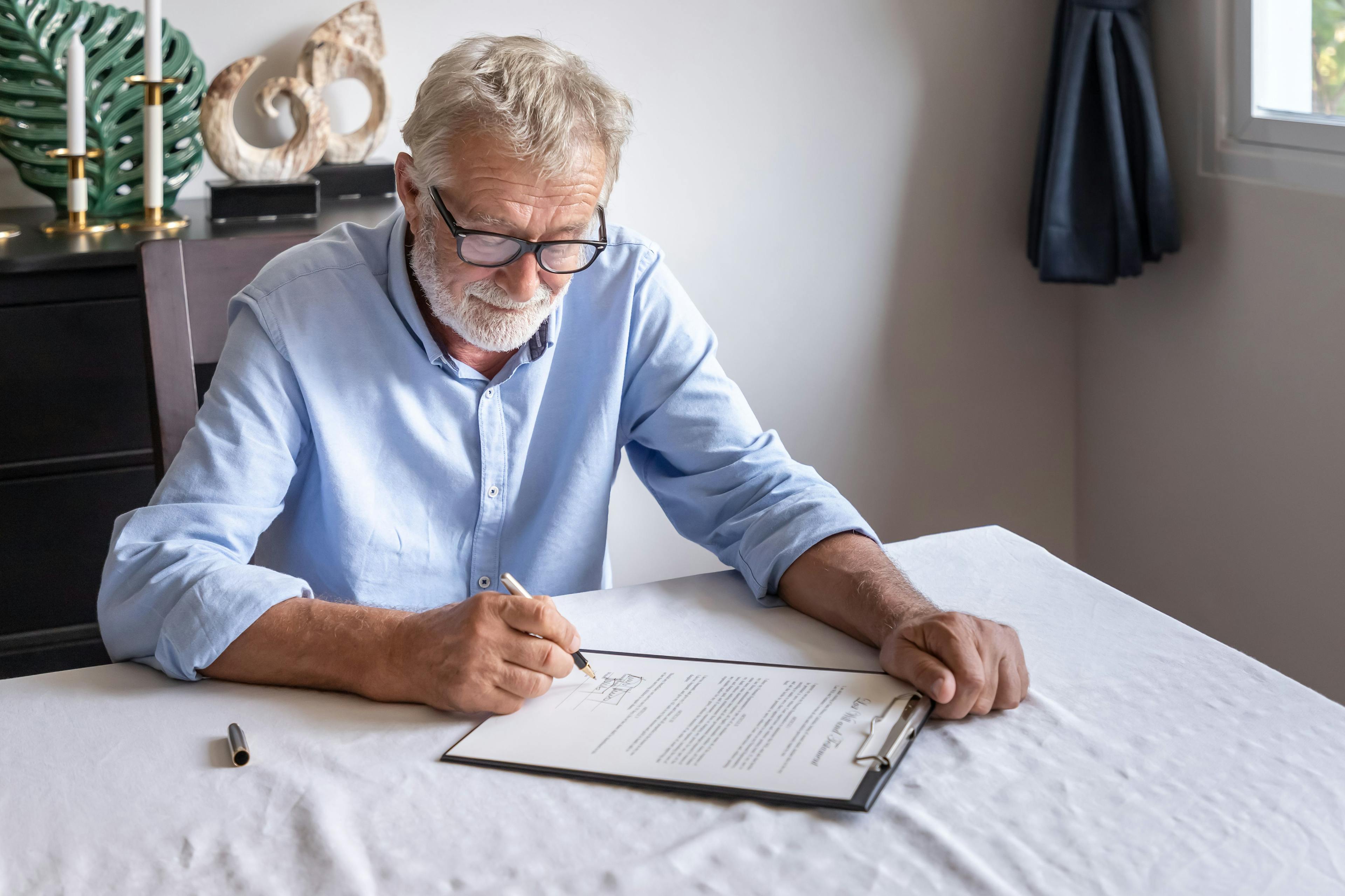 An old man signing a contract