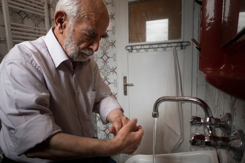 Old man washing his hands