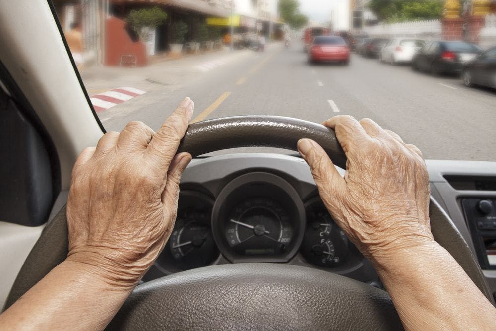 Older woman's hands as she drives a car