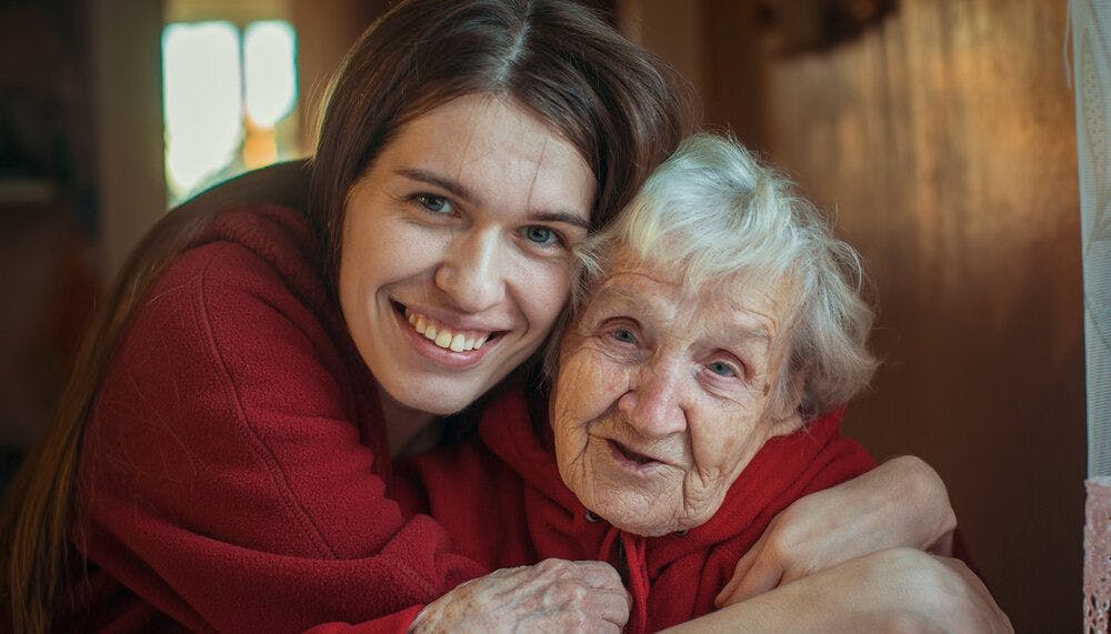 A woman hugging her elderly grandmother