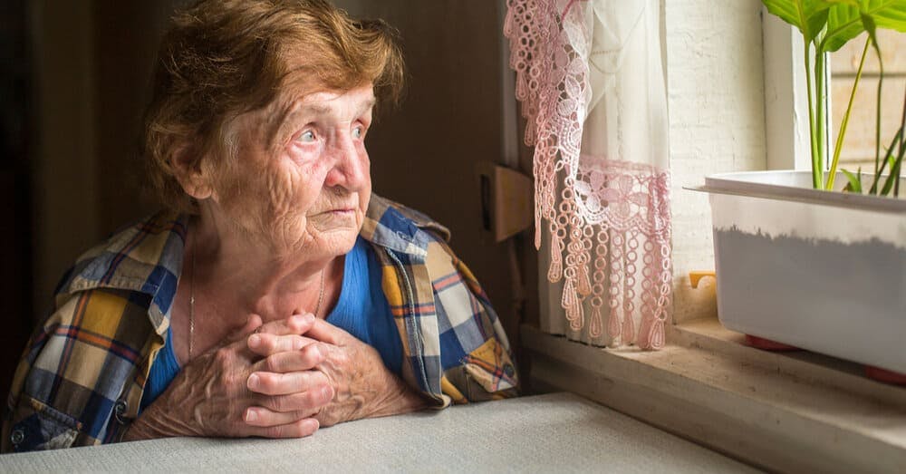 An unhappy elderly lady looking out of the window